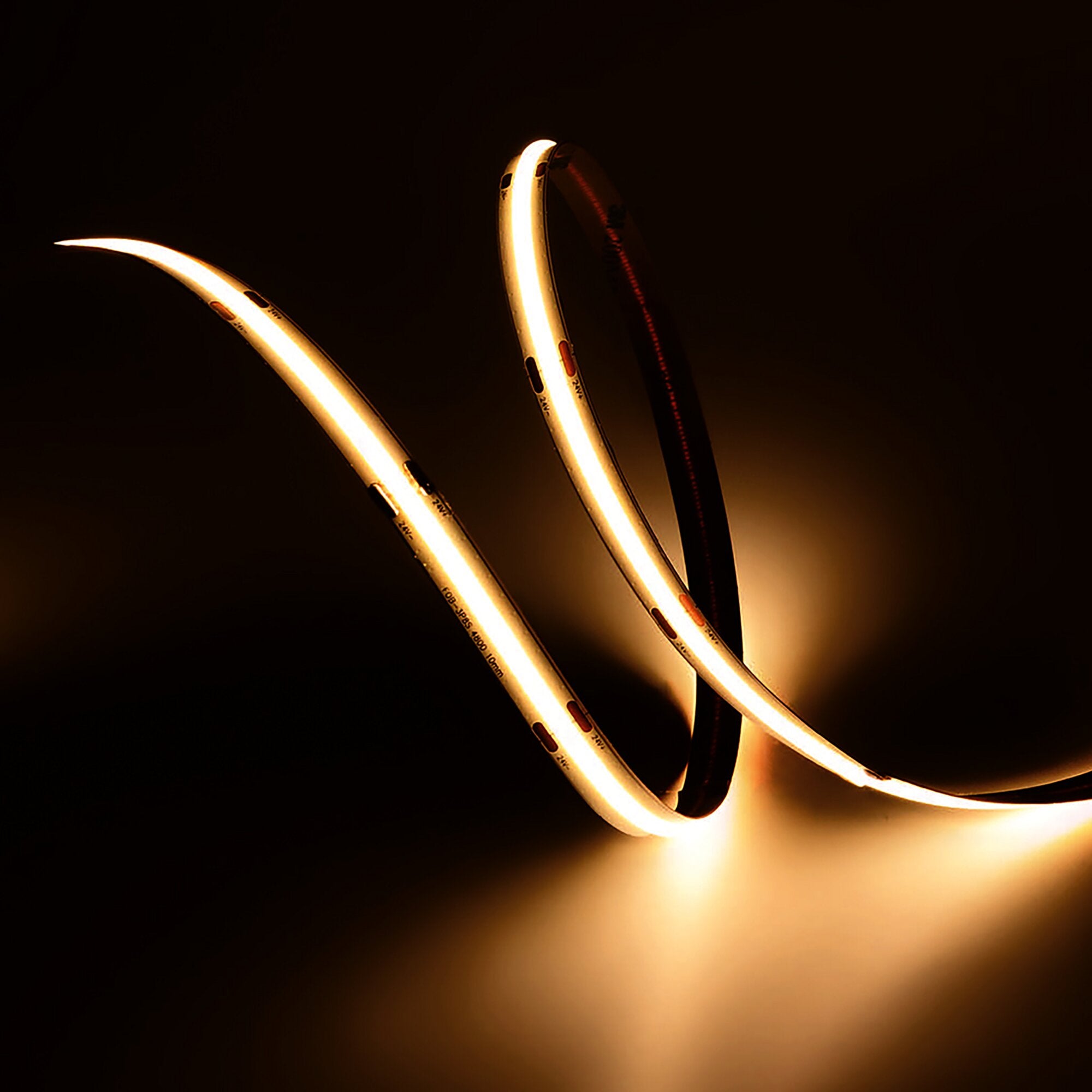 Warmweißes LED-Lichtband, flexibel gebogen, mehrere Streifen vor dunklem Hintergrund, 100 cm lang, leuchtende LED-Reihe sichtbar