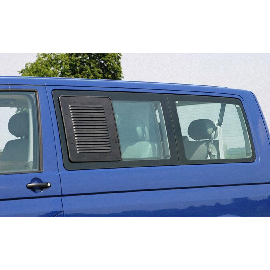Schwarzes, rechteckiges Lüftungsgitter Airvent installiert am linken Fensterausschnitt eines blauen VW T6.1 Transporters