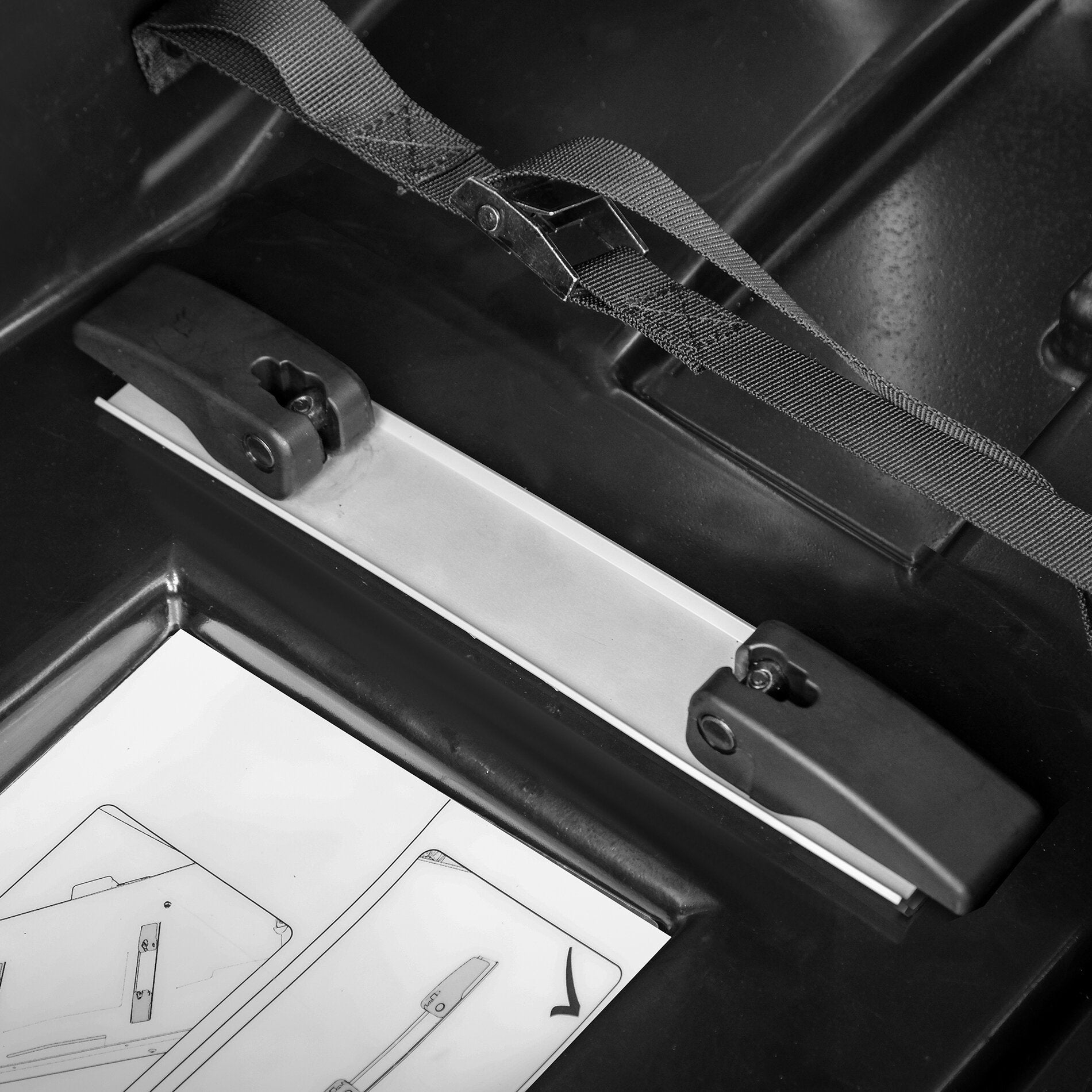 Detailaufnahme eines schwarzen Innenraum einer Transportbox mit Nylon-Gurtband und Metall-Schnalle