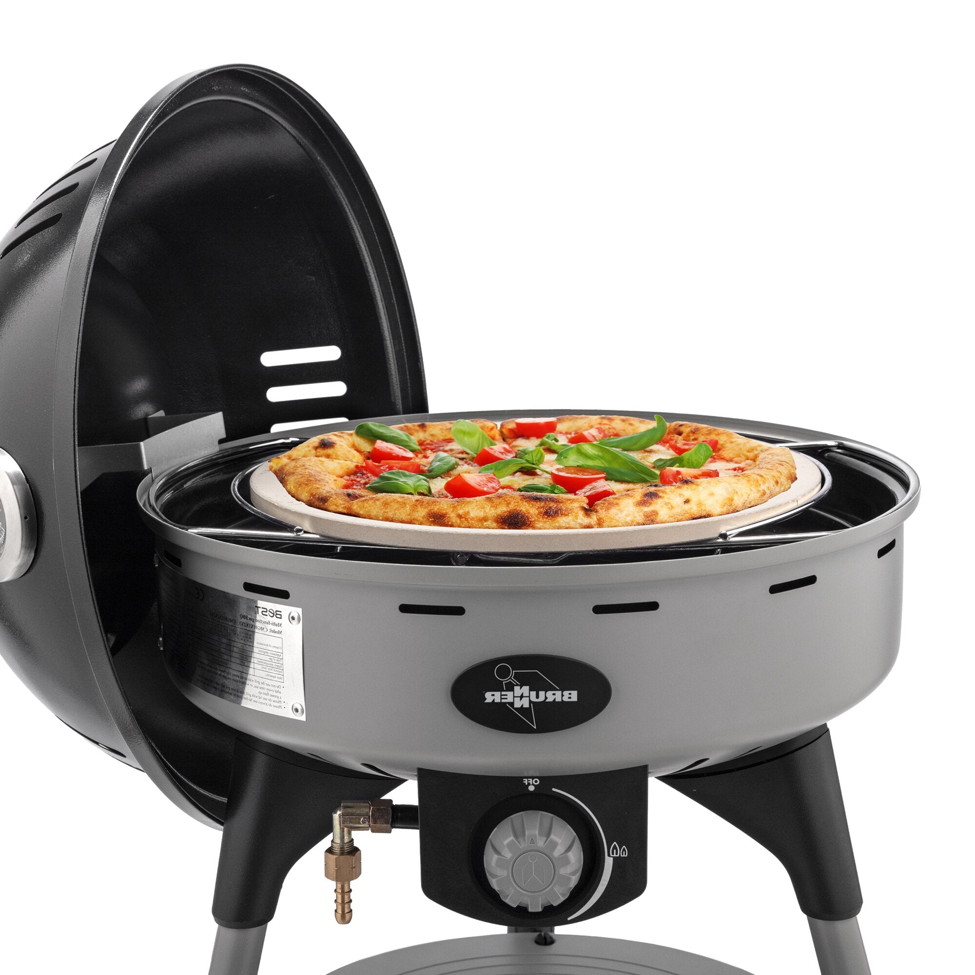 Belegte Pizza liegt auf einem Pizzastein in einem elektrischen Ofen mit Lüftungsschlitzen
