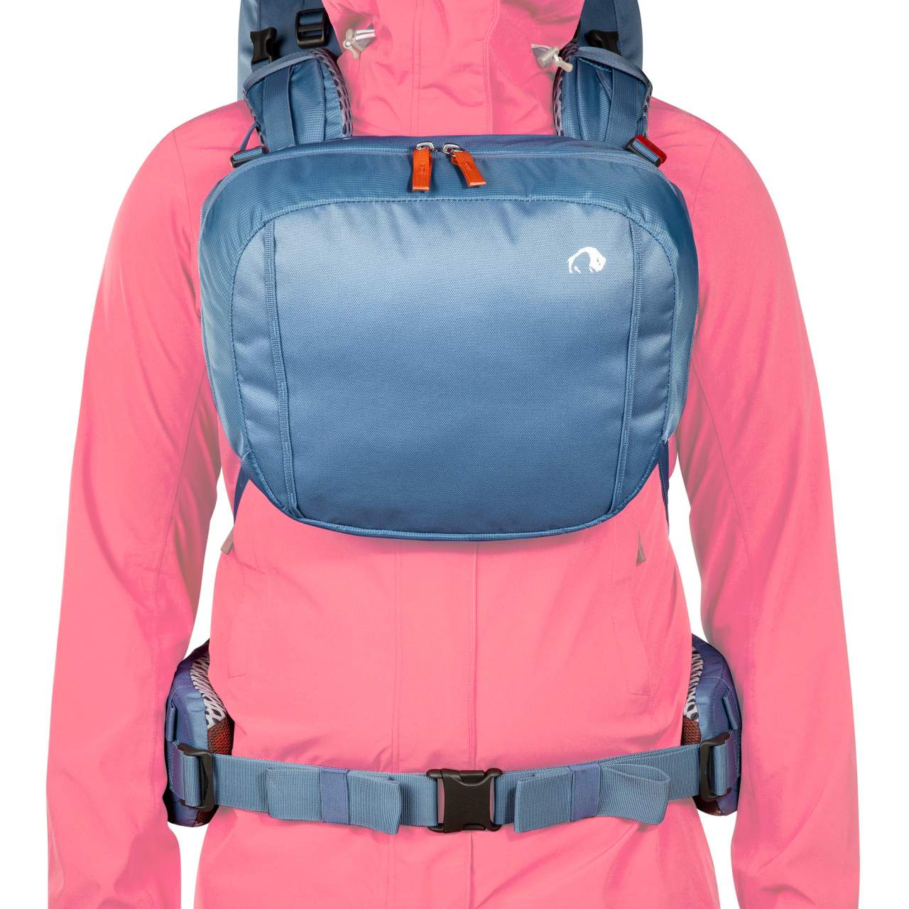 Blauer kompakter Trekkingrucksack mit breitem Hüftgurt und verstellbaren Schulterriemen, auf pinker Outdoorjacke getragen,.