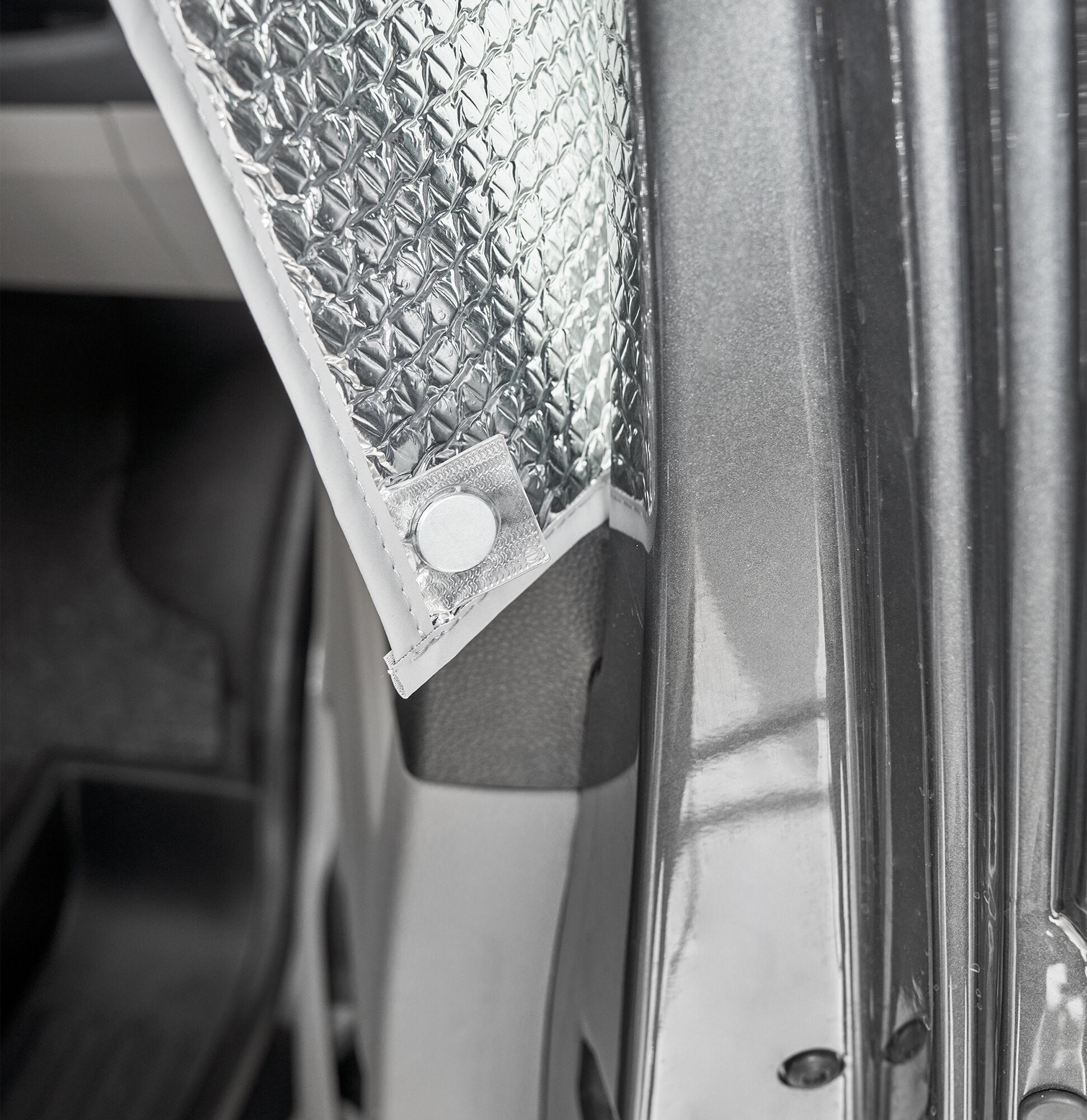 Detailaufnahme einer anthrazitfarbenen Innenisoliermatte Travel mit silberner Diamond-Plate-Oberfläche, geprägtem Muster und Randnaht