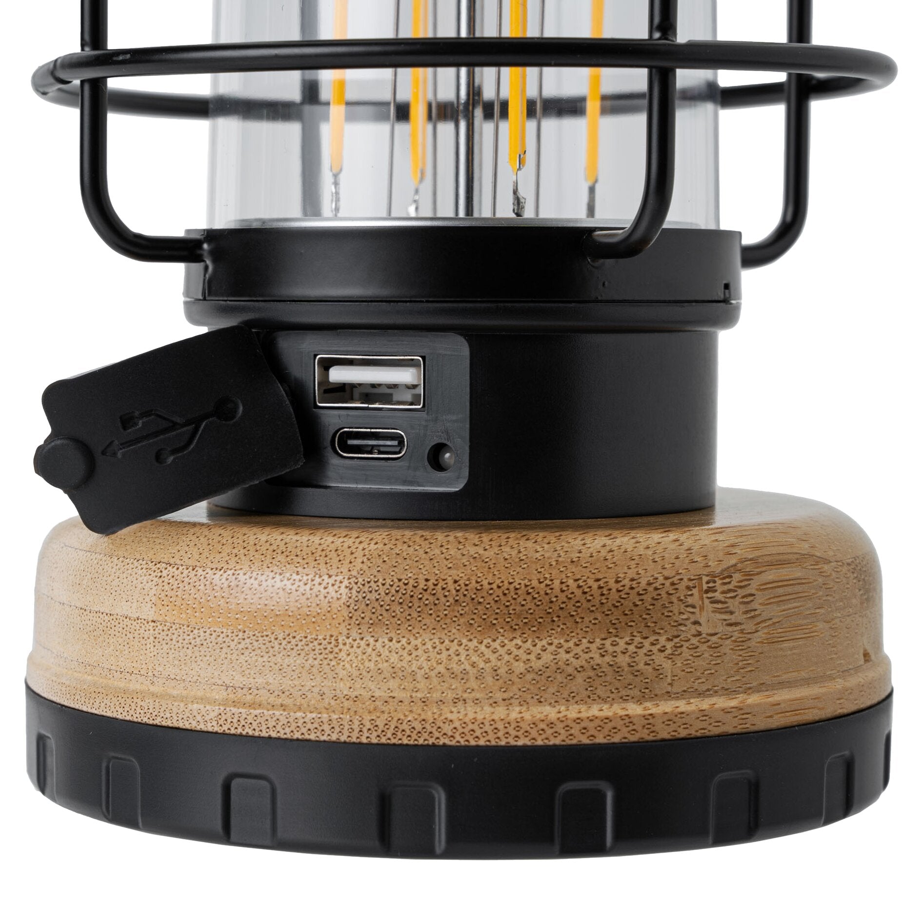 Detailansicht einer schwarzen Campinglampe mit Glaszylinder, Metallrahmen und sichtbaren LED-Fäden; Holzunterteil und USB-Ladeanschluss