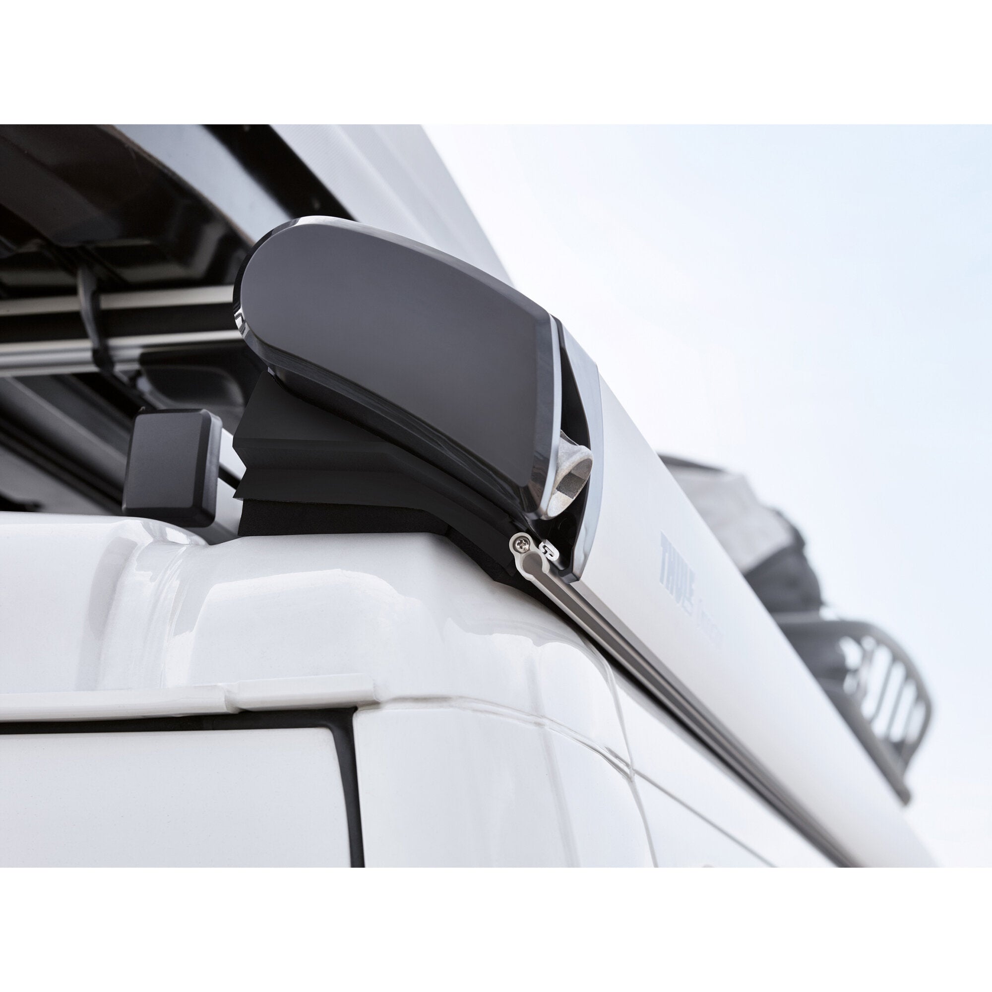Nahaufnahme eines grauen eloxierten Markisenarms an der Seite eines weißen Fiat Ducato, Gehäuse und Halterung deutlich sichtbar