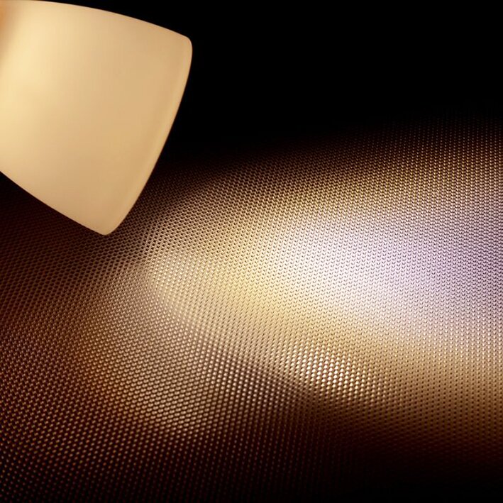 Aufbau-Leseleuchte aus Echtglas, warmweißes Licht 3000 K strahlt von links oben auf eine feine Punktraster-Oberfläche mit Glanz- und Schattenmustern