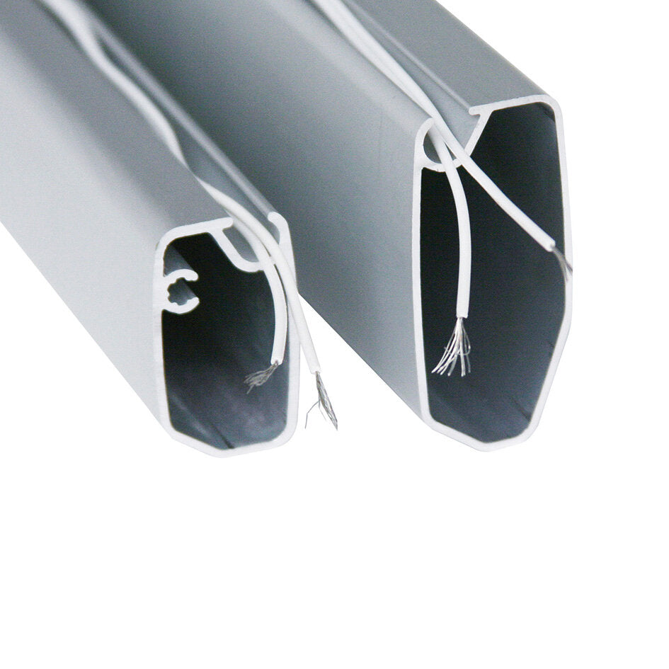 Detailansicht von zwei hellgrauen Aluminiumprofilen mit rechteckigem, abgerundetem Querschnitt; weiße Innenkanten und weiße Drähte ragen aus den Enden