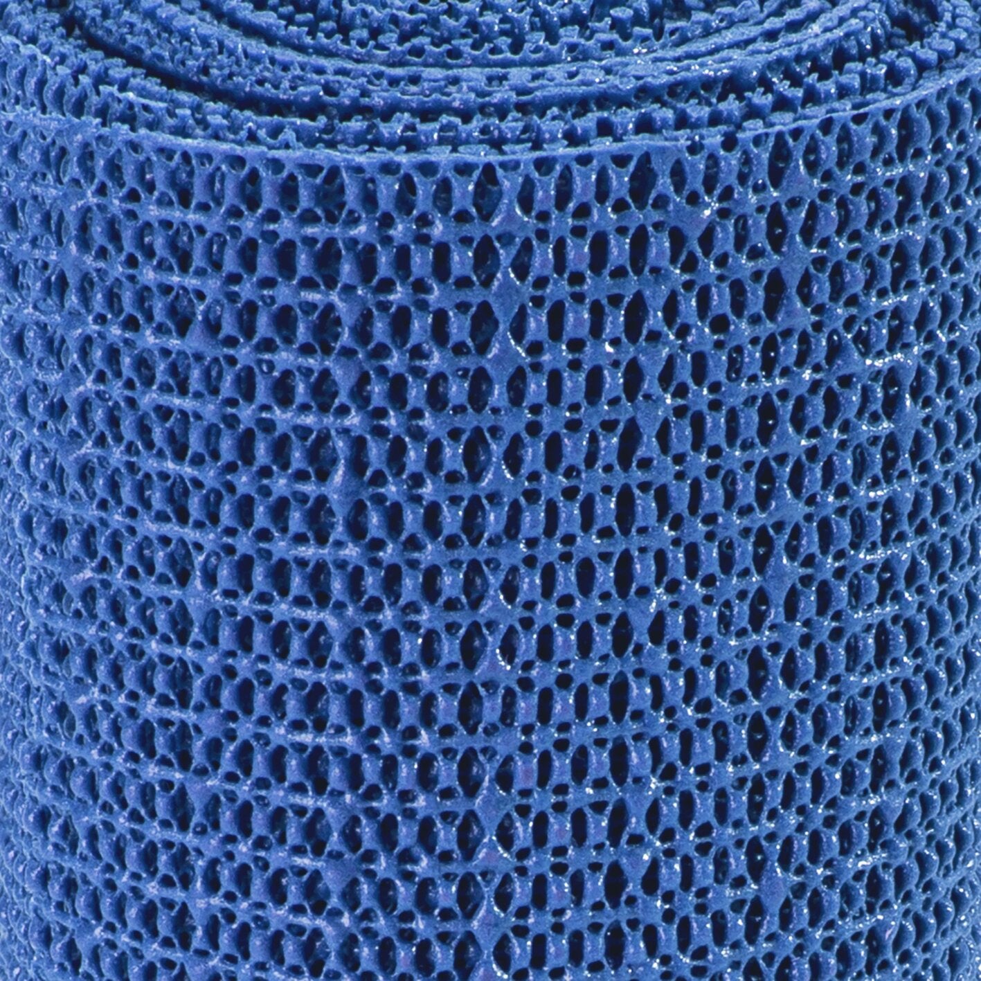 Nahaufnahme einer blauen Antirutschmatte mit offener, poröser Schaumstoffstruktur und zahlreichen ovalen Löchern in der Oberfläche