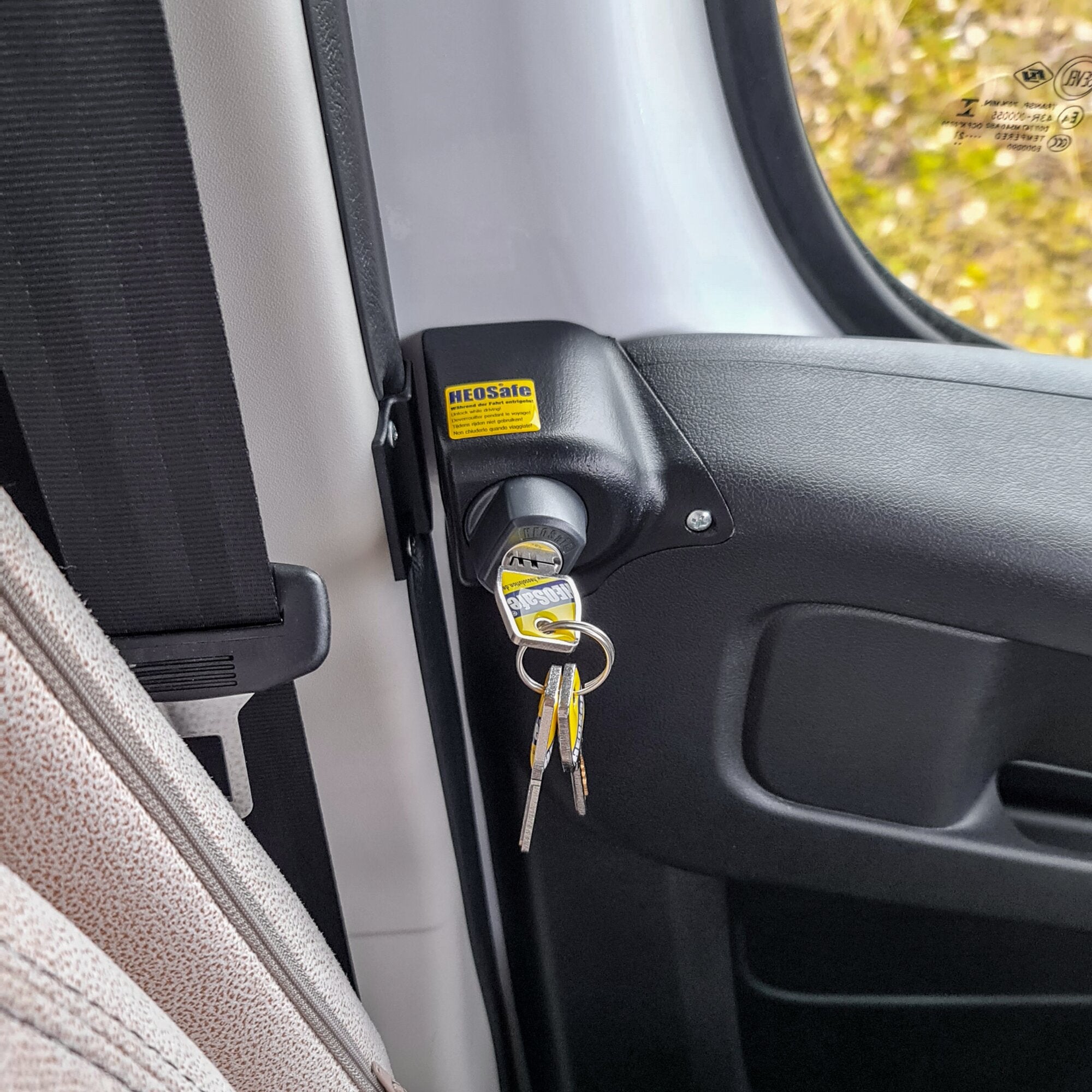 Innenansicht der Fahrertür eines Fiat Ducato X290 mit Diebstahlschutzschloss und Schlüsselbund, gelber HEOSafe-Aufkleber an der Türverkleidung