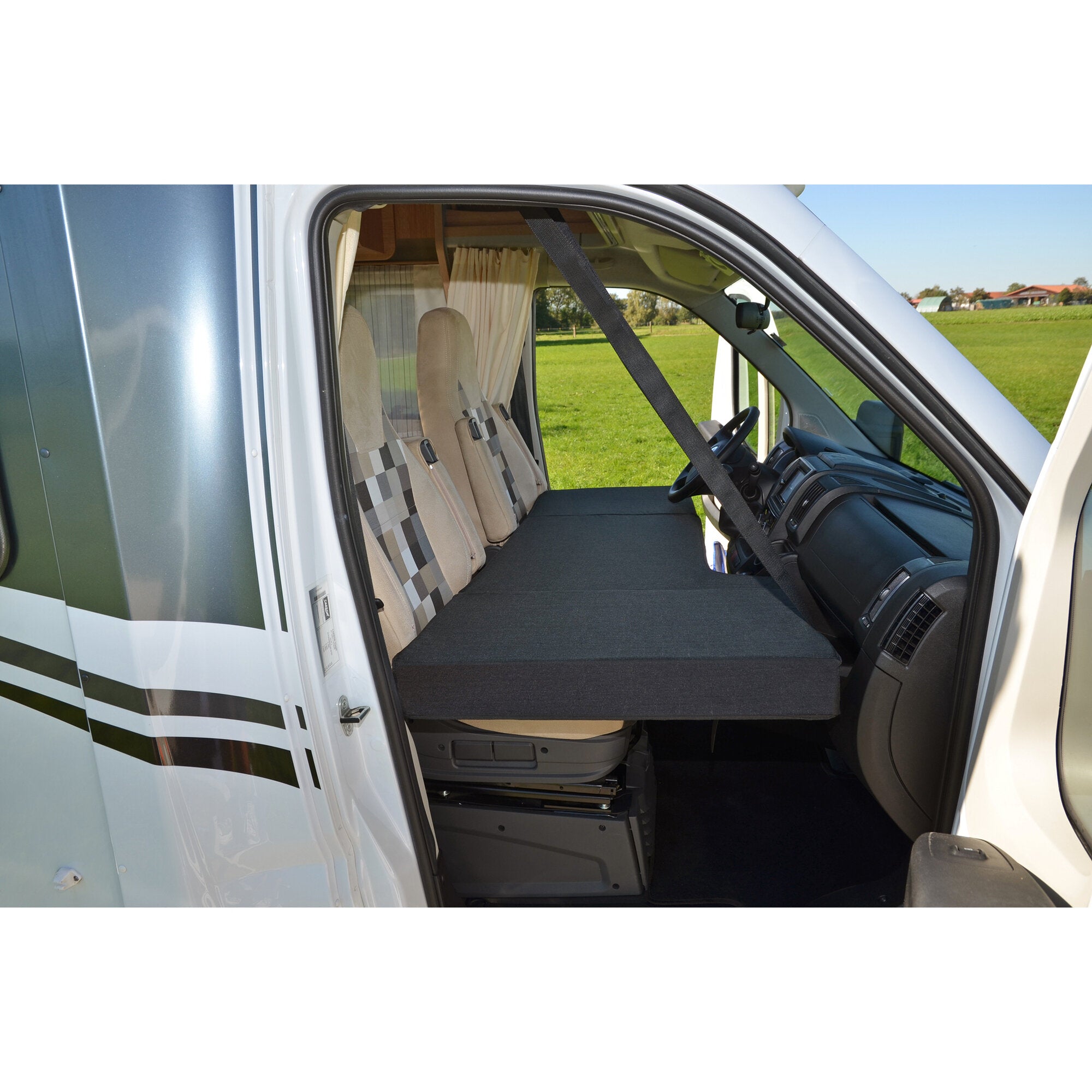 CampSleep Fahrerhaus-Matratze 73 x 160 cm liegt im Fahrerhaus eines Wohnmobils als Schlaffläche; dunkelgraues Polster bedeckt die Sitze