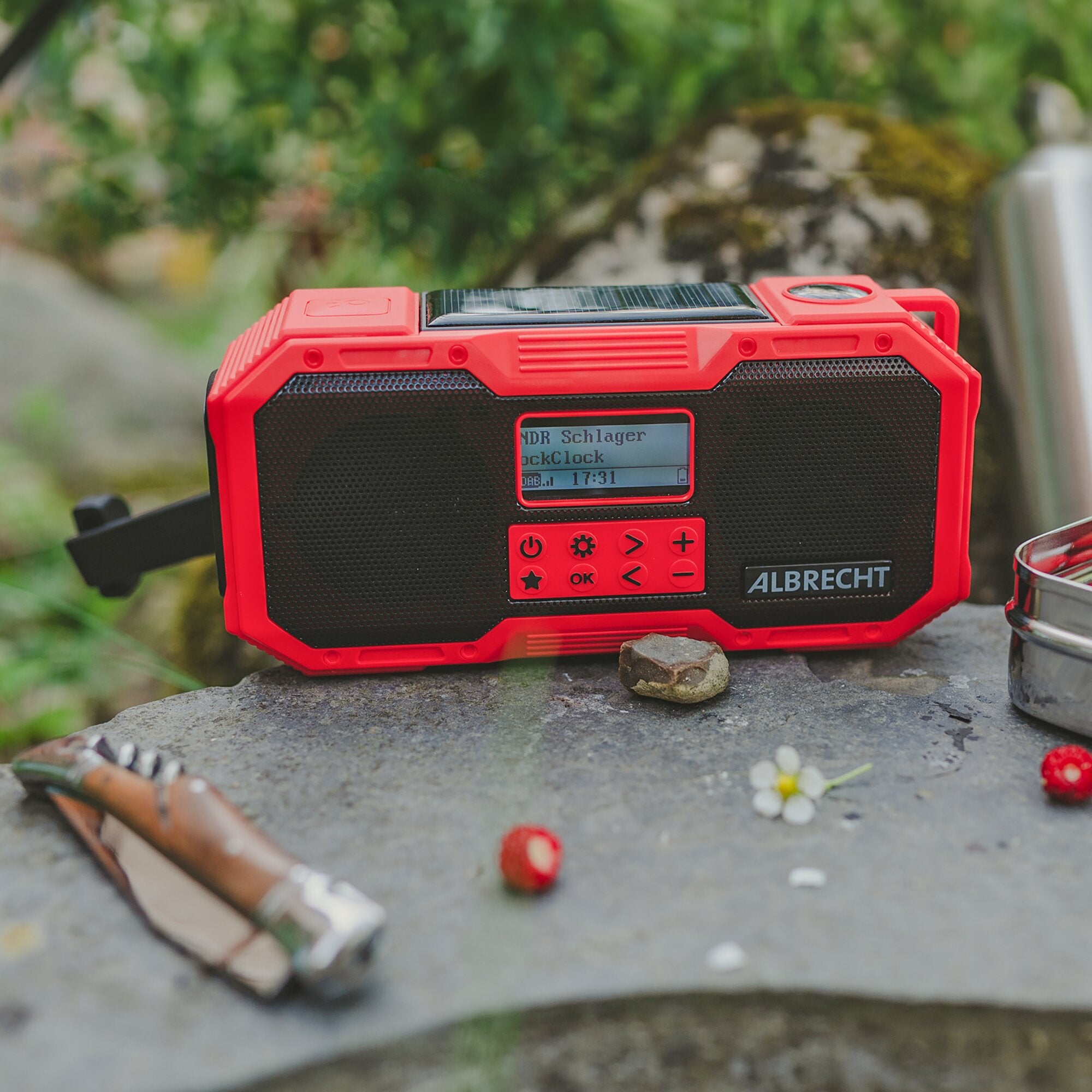 Rotes Albrecht Outdoor-Radio mit Solarpanel auf dem Gehäuse, schwarzem Lautsprechergrill, rotem Bedienfeld mit Tasten und kleinem Display