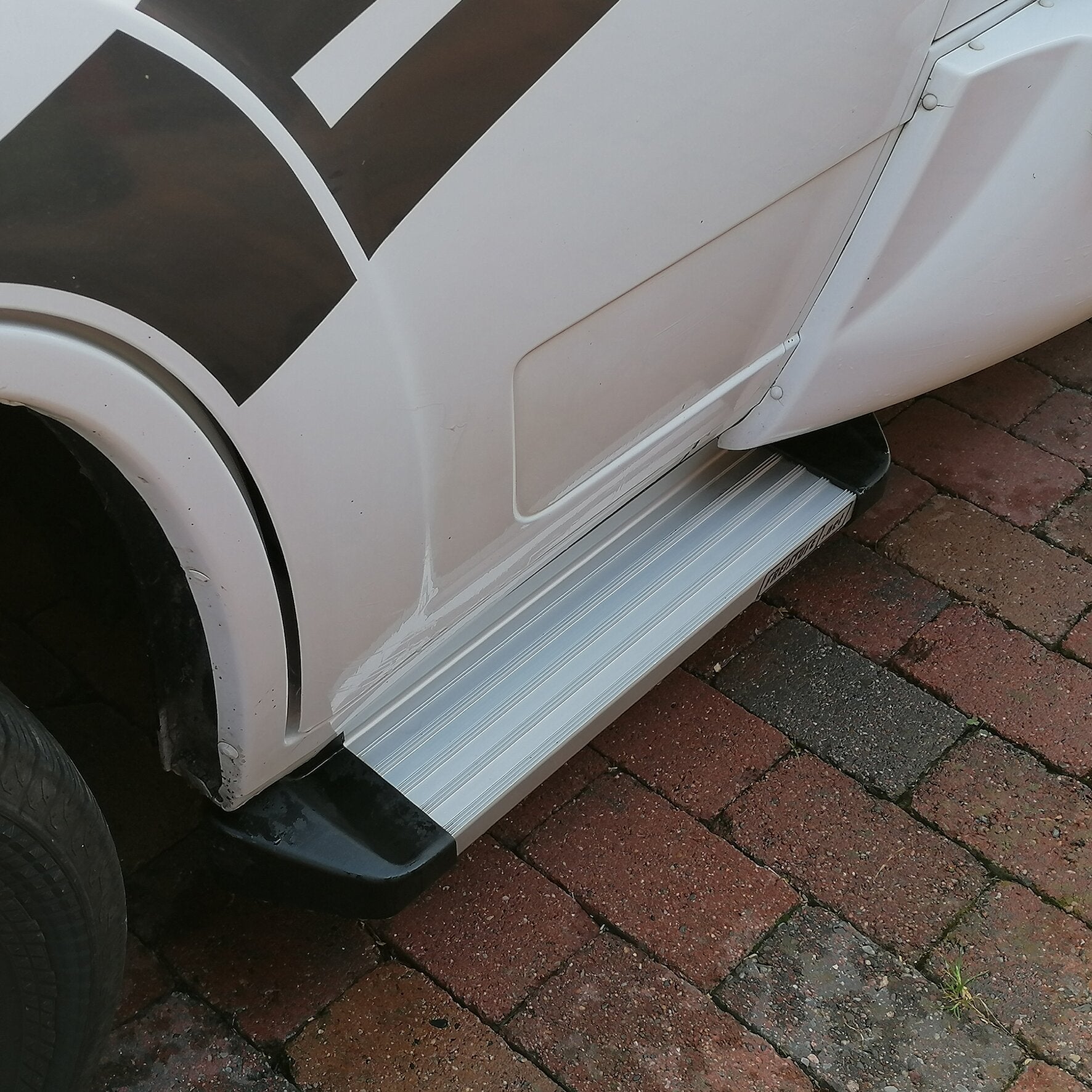 Seitenansicht eines weißen Fiat Ducato X250/X290 mit einer metallischen Freistufe am unteren Türbereich, rutschfest und geriffelt
