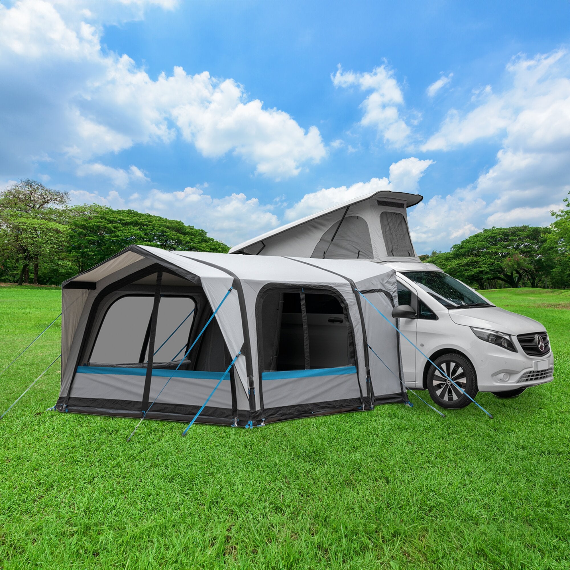 Busvorzelt Wise A.I.R. Tech am Campervan, graues Vorzelt mit seitlichem Eingang, Abspannseile in Blau, grüne Wiese und Himmel im Hintergrund