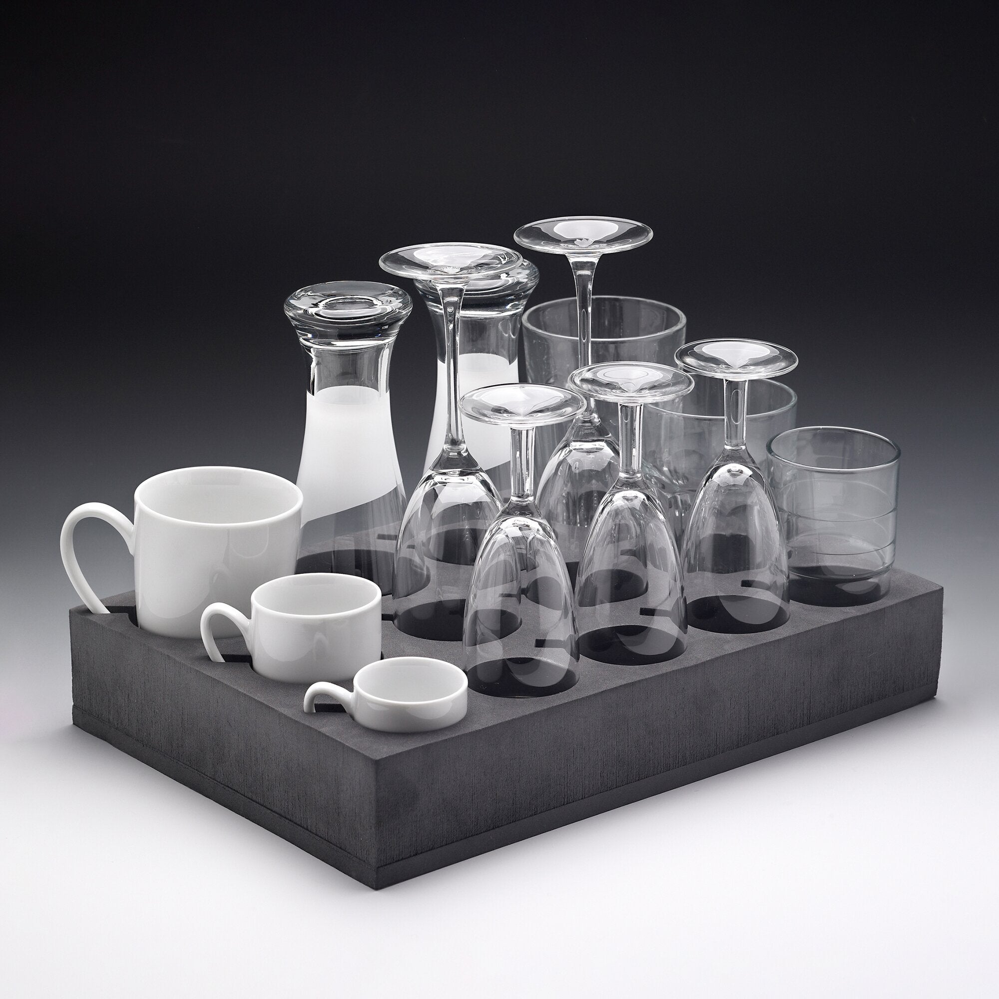 Grauer Universal-Glas-/Tassenhalter mit runden Fächern, darin verschiedene klare Gläser und weiße Kaffeetassen vor dunklem Hintergrund