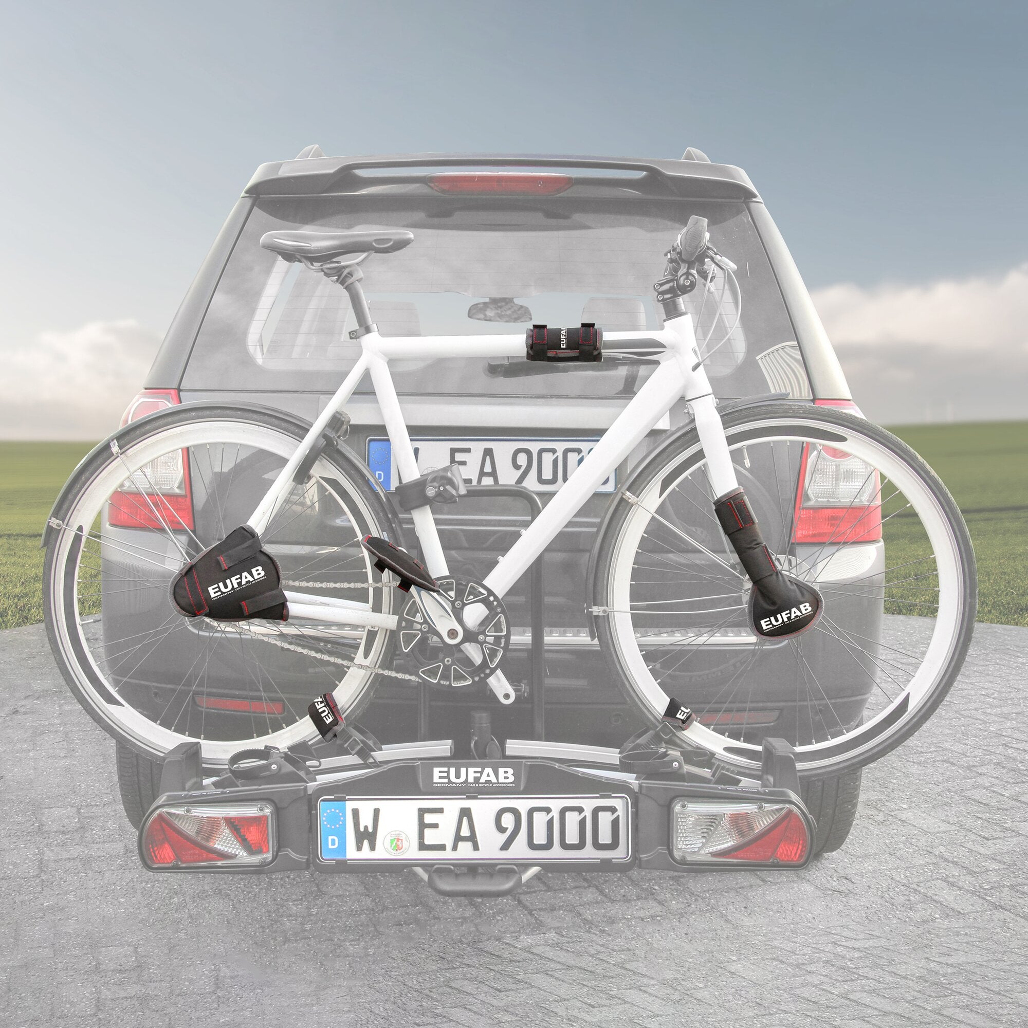 Rückseite eines Autos mit Heck-Fahrradträger, zwei weiße Rennräder, an den Rahmenelementen sichtbare EUFAB Schutztaschen aus schwarzem Material