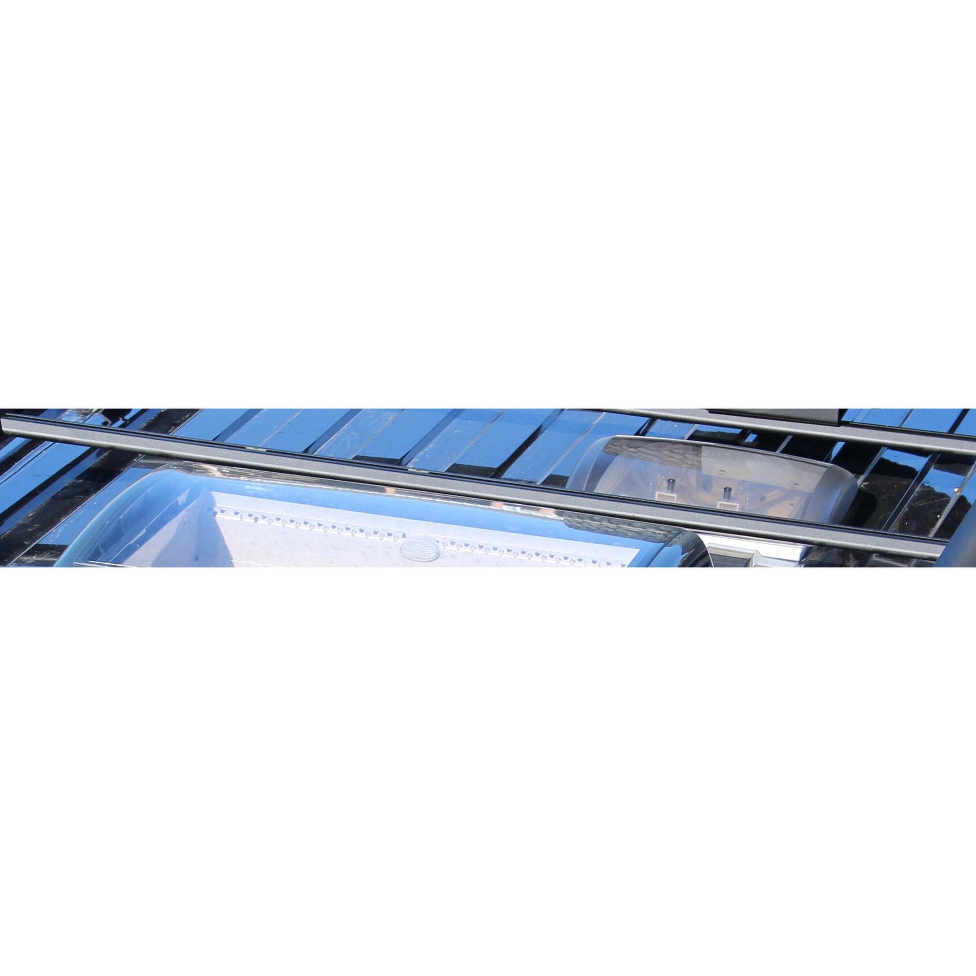 Horizontale schwarze Querträger des Adventure Roof Dachgepäckträgers auf dem Dach eines VW T5/T6, sichtbare Trägerrohre und Befestigungselemente