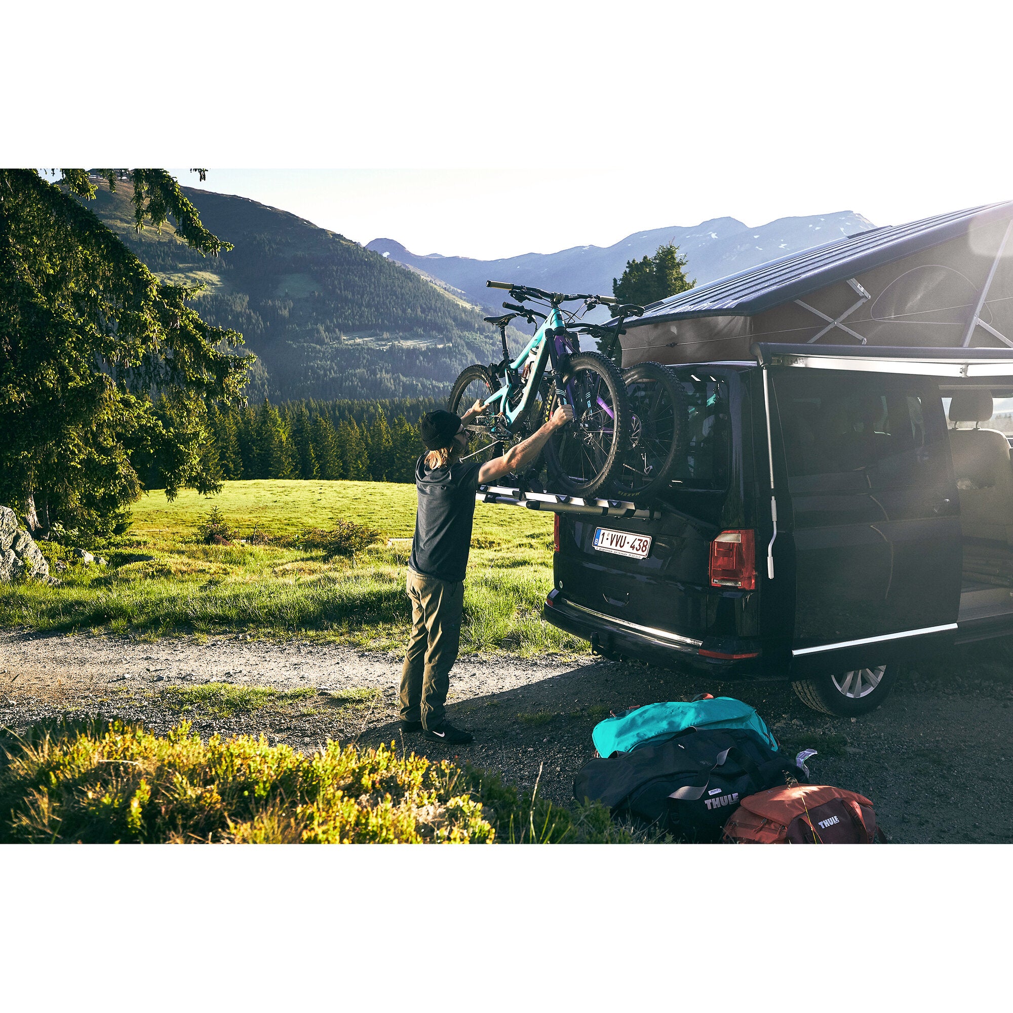 VW T6 mit Thule WanderWay Fahrradträger am Heck, zwei Mountainbikes befestigt, Berglandschaft im Hintergrund