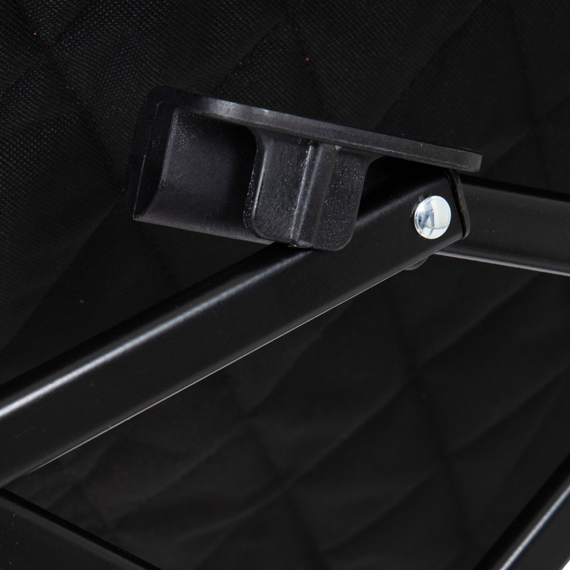 Detailaufnahme eines schwarzen Klappstuhl-Befestigungswinkels mit sichtbarem Metallbolzen an einem schwarzen Rahmen, Hintergrund Stoff