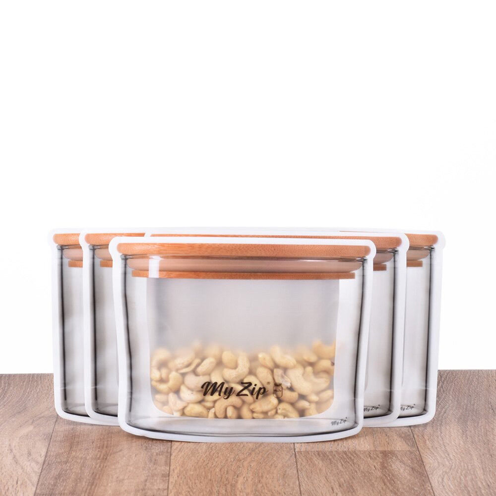 Fünf transparente Aufbewahrungsbeutel mit weißem Rand und Holzdeckeln, vorderer Beutel mit Cashews gefüllt, 850 ml Breit