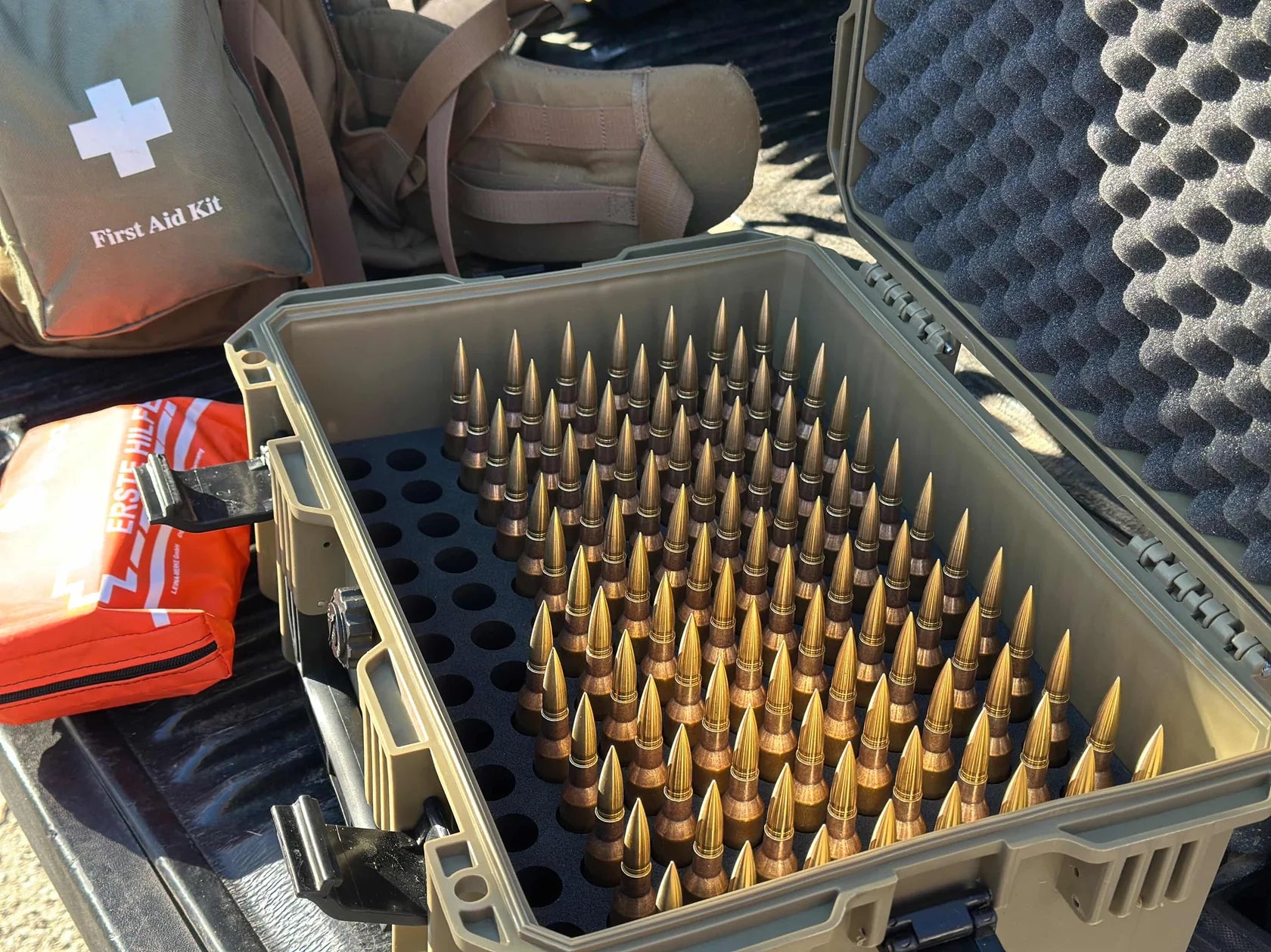 Robuster grauer Hartschalenkoffer mit offenem Deckel, innen mit Schaumstoff ausgekleidet, gefüllt mit mehreren Reihen von.