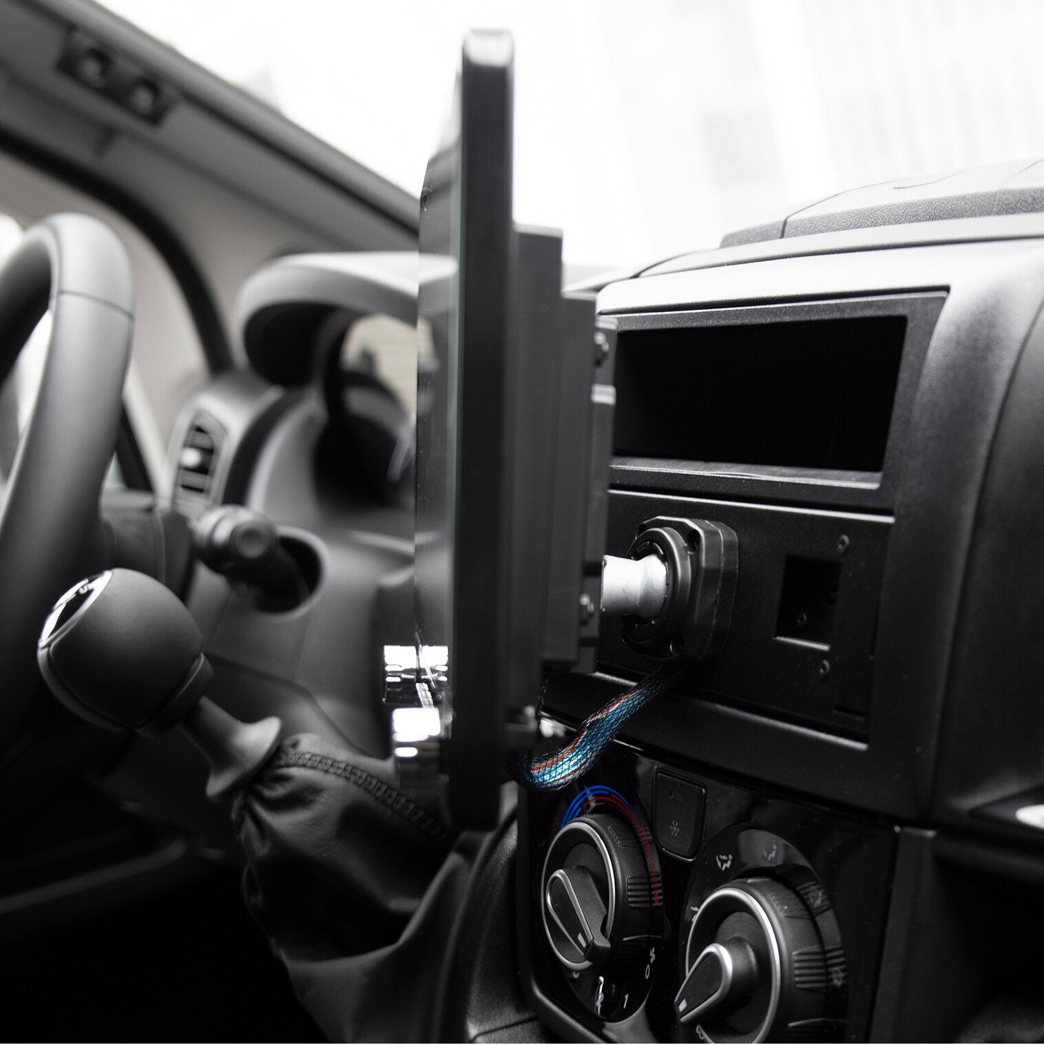 Innenraum eines Autos mit vertikal montiertem Navigationsdisplay ESX Vision VNC1061, sichtbar Kabelanschluss und darunter Klimabedienelemente