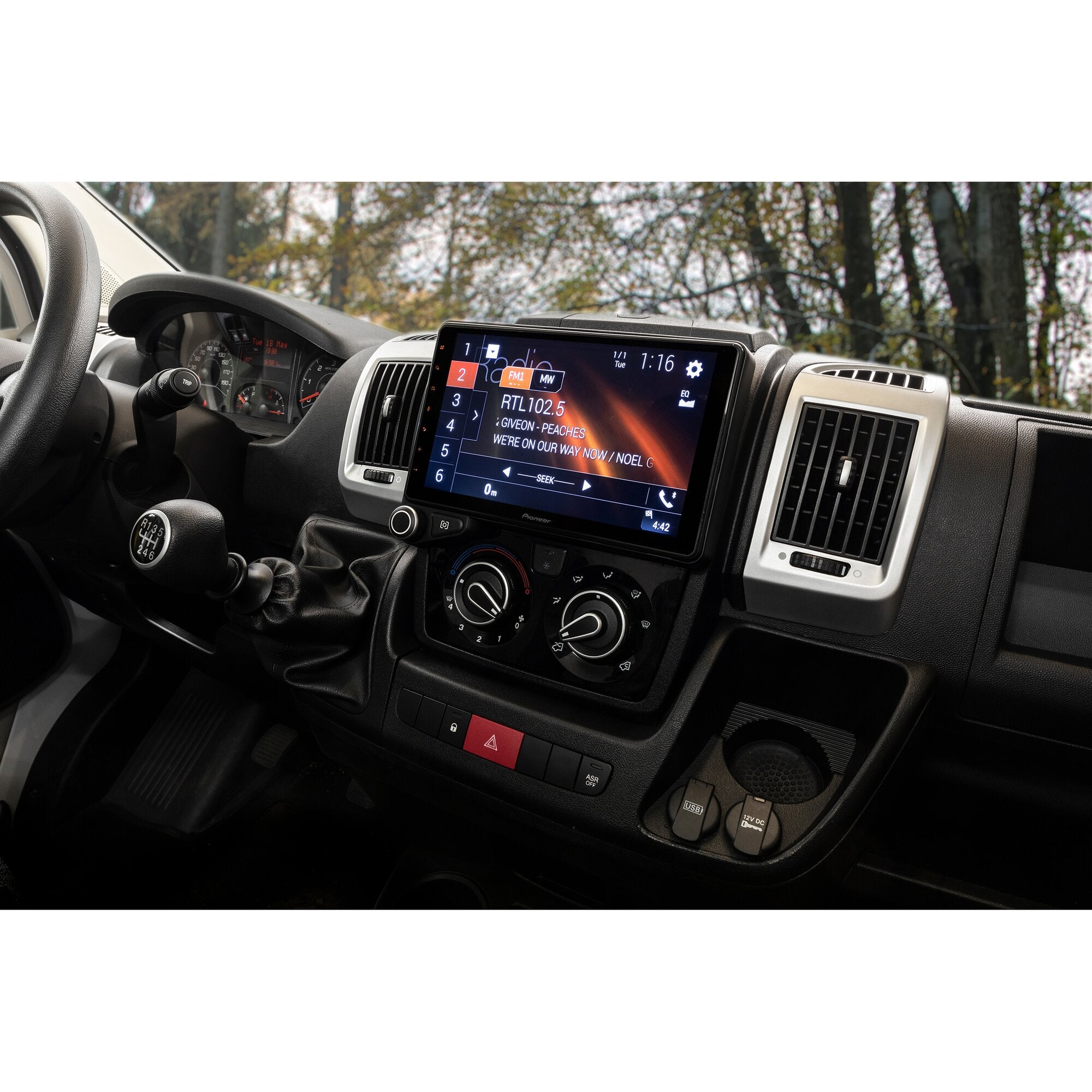 Im Armaturenbrett eines Autos sitzt ein großes Touchscreen-Navigationssystem Pioneer AVIC-Z1000, umgeben von Klimasteuerung und Warndreieck