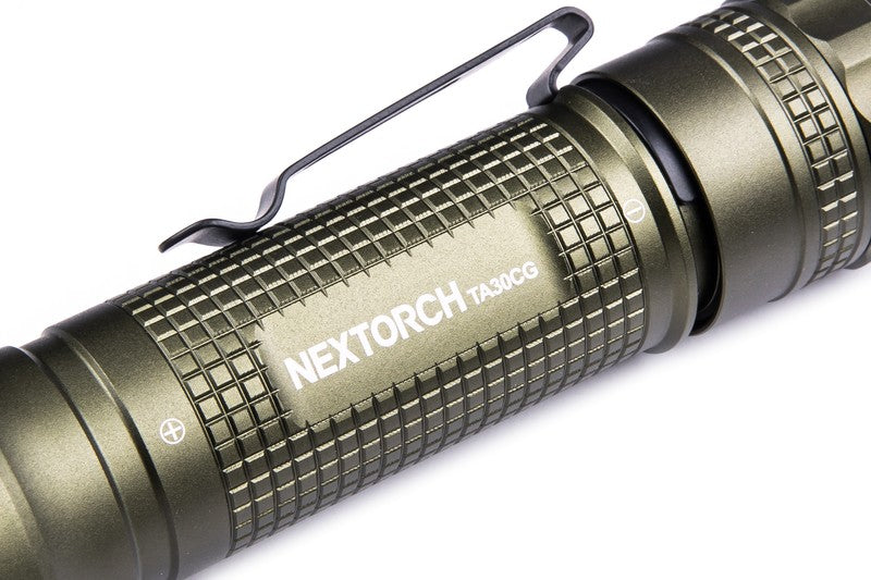 Grüne NEXTORCH TA30CG K.I.S.S. Einsatzlampe mit geriffeltem Griff, Metallclip und weißem Logo auf dem Gehäuse.