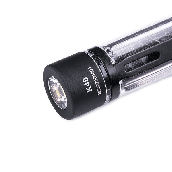 Kleine kompakte NEXTORCH K40 Mini-Taschenlampe mit schwarzem Kopf und transparentem Gehäuse, sichtbar LED-Linse von vorne.