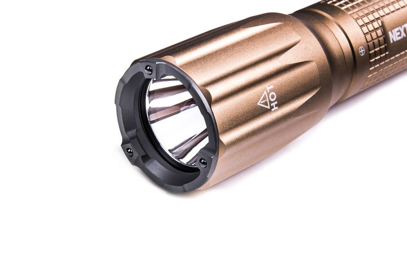 Sandfarbene taktische NEXTORCH TA30CS Einsatzlampe mit reflektierendem LED-Licht und griffiger Struktur am Griff.