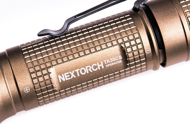 Sandfarbene taktische Taschenlampe NEXTORCH TA30CS mit geriffeltem Griff und USB-C Ladeanschluss.