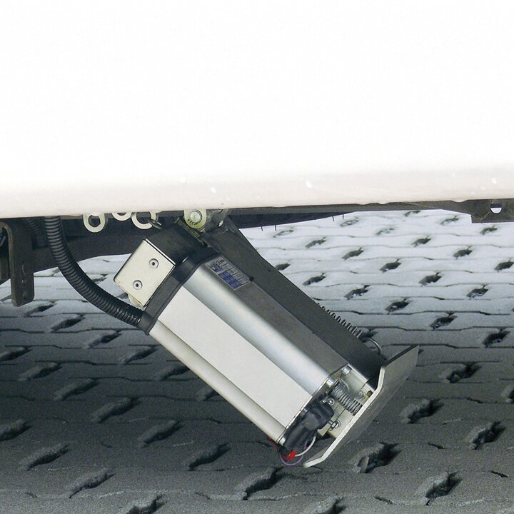 Unter dem Fahrzeug sichtbar ist eine silberne Hydraulikzylinder-Liftkomponente einer Vier-Stützenanlage mit schwarzen Enden
