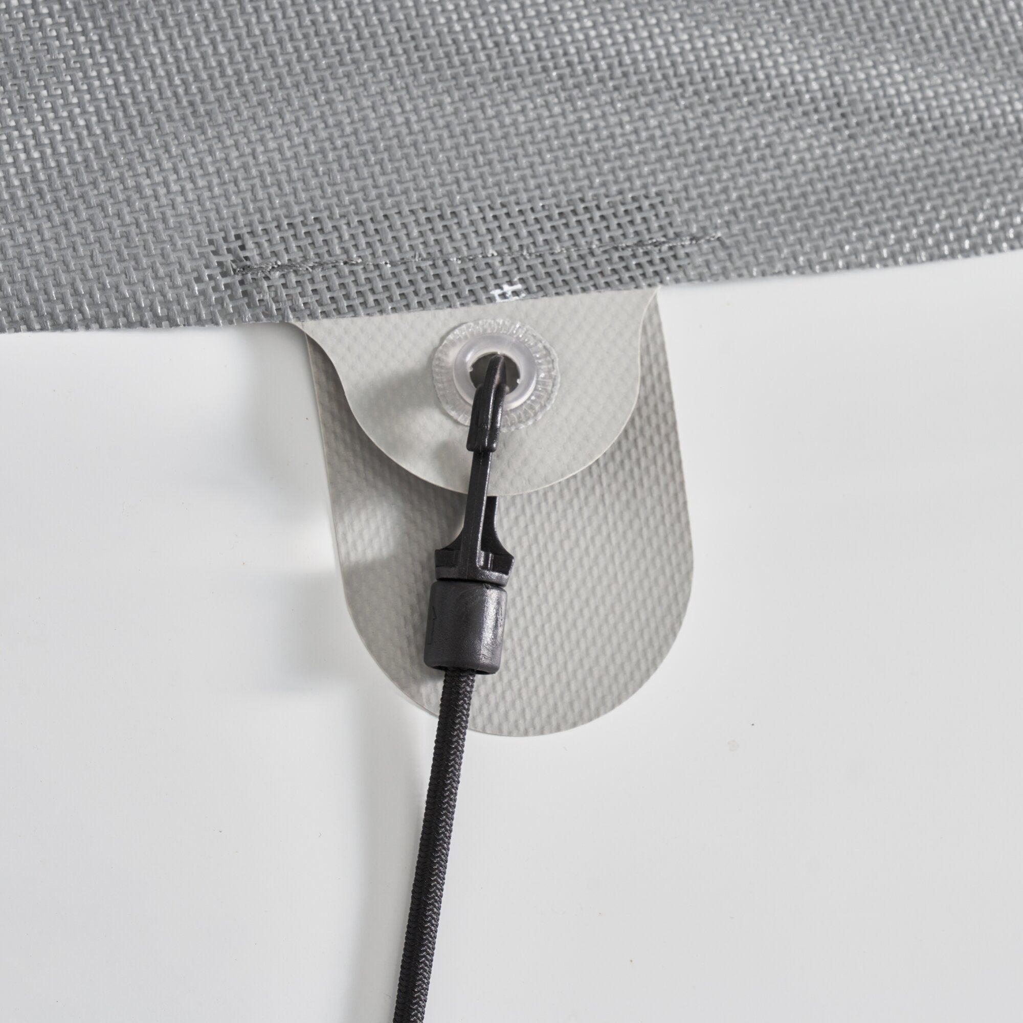 Detailaufnahme einer grauen gewebten Sonnenschutzmatte Screen, befestigt an einer metallischen Halterung mit schwarzem Kabel am Rand