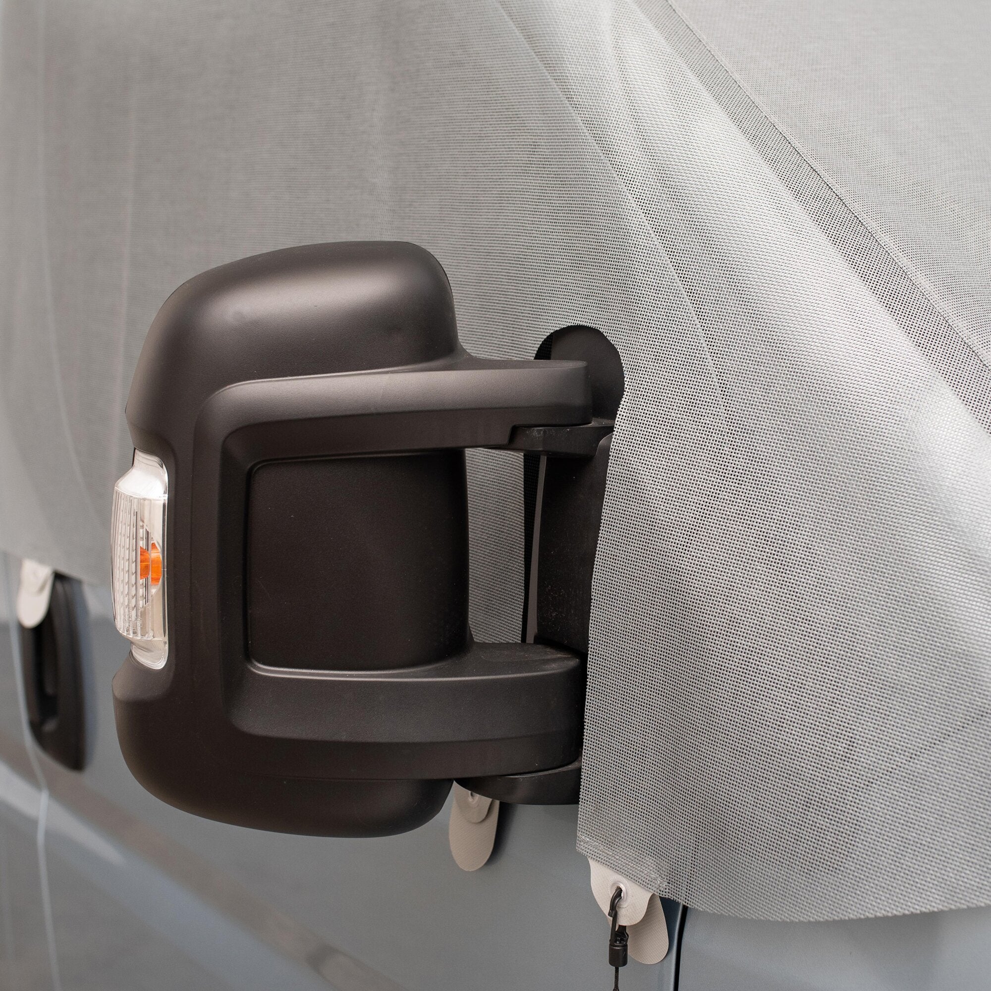 Sonnenschutzmatte Screen am Seitenfenster eines VW Crafter Gen. 2 / MAN TGE, graues perforiertes Gewebe in schwarzer Kunststoffhalterung