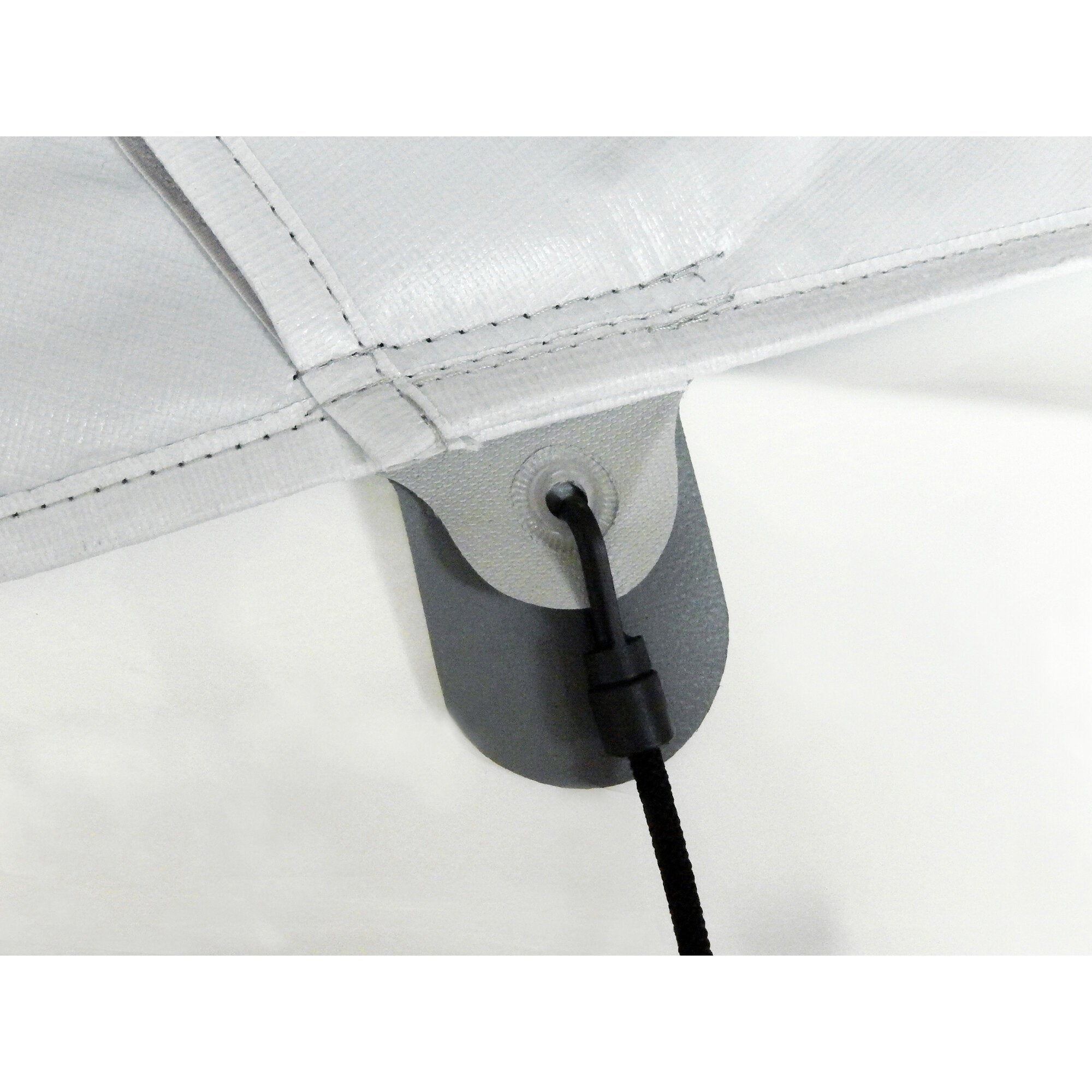 Detailaufnahme der weißen Thermomatte LUX-DUO Oberteil, sichtbar sind Nähte, Stoffkante und eine schwarze Schnur an einer Befestigungslasche