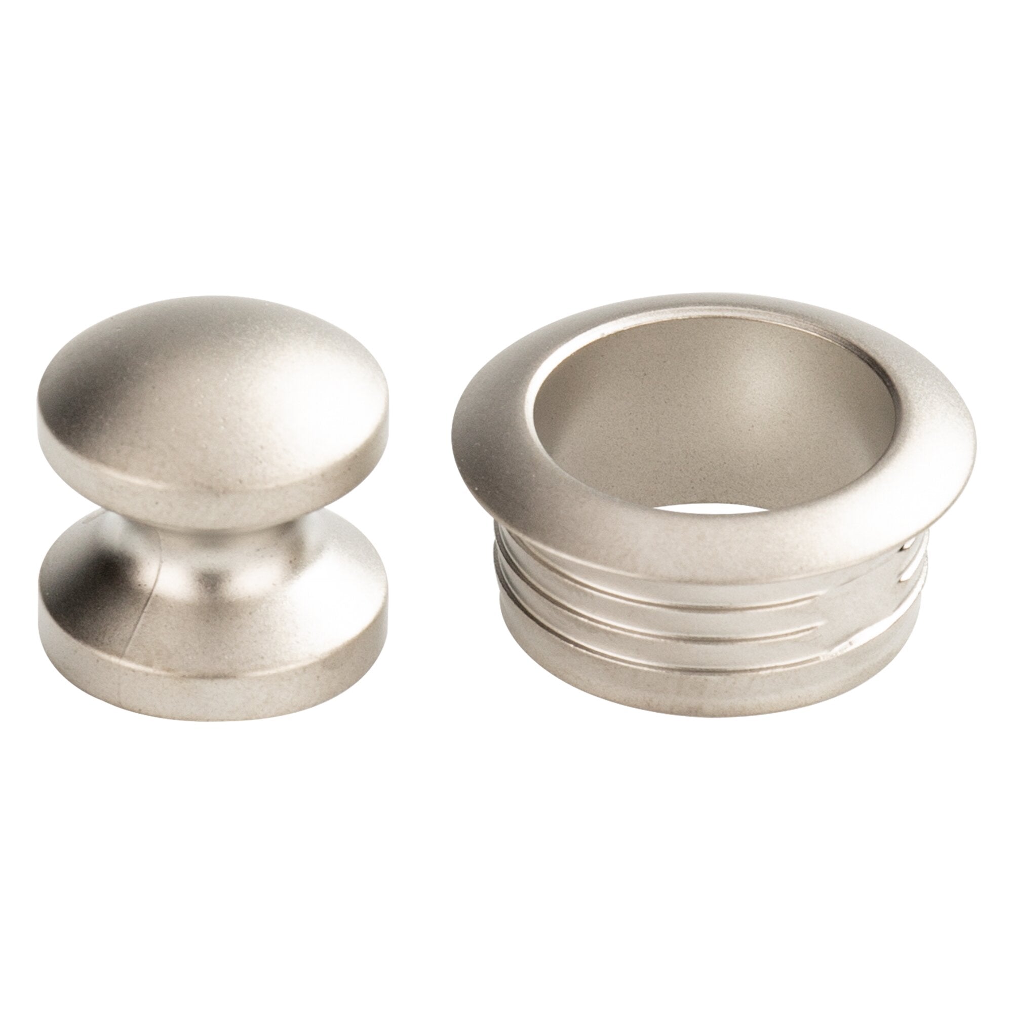 Nahaufnahme silberner Druckknöpfe und Metallteile: zwei runde Knopfdeckel, ringförmiges Gehäuse mit Innenring