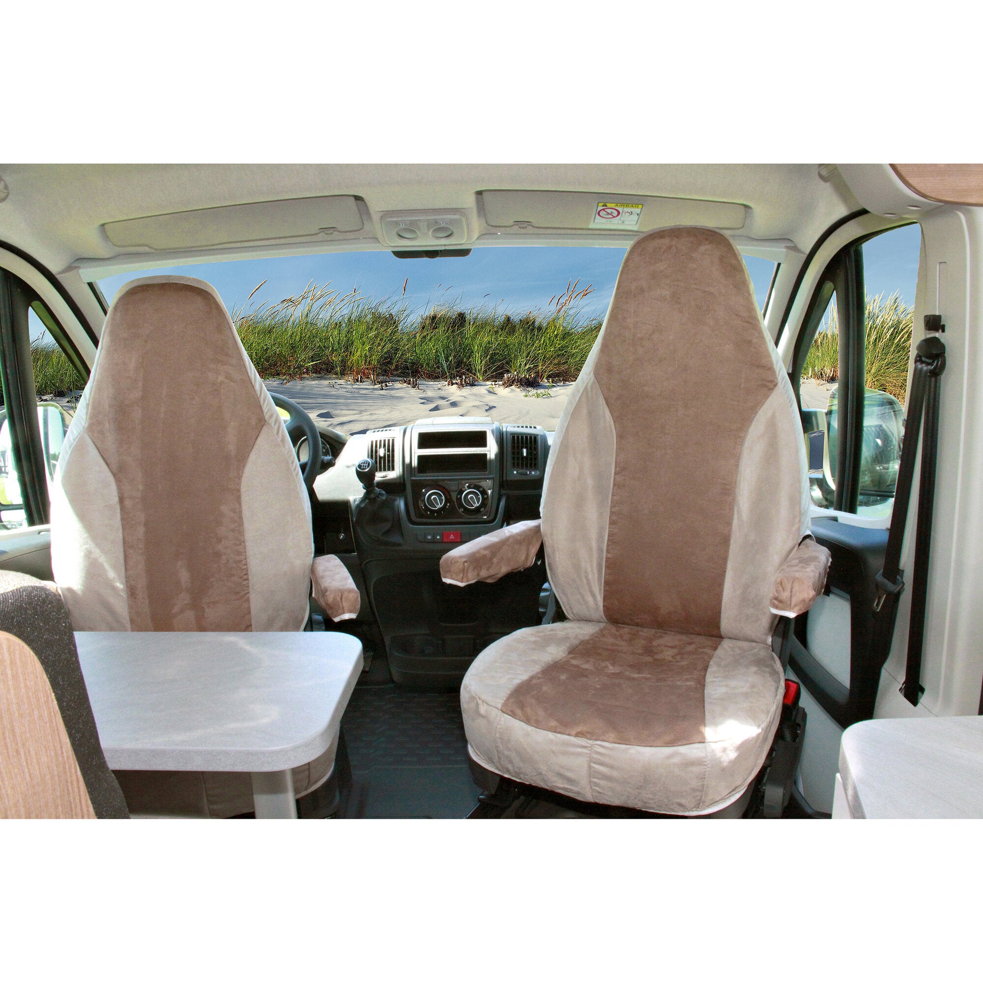 Innenraum eines Vans mit sandfarbenen Schonbezügen auf den vorderen Sitzen, beige Dachhimmel, Mittelkonsole und ein grauer Tisch im Vordergrund