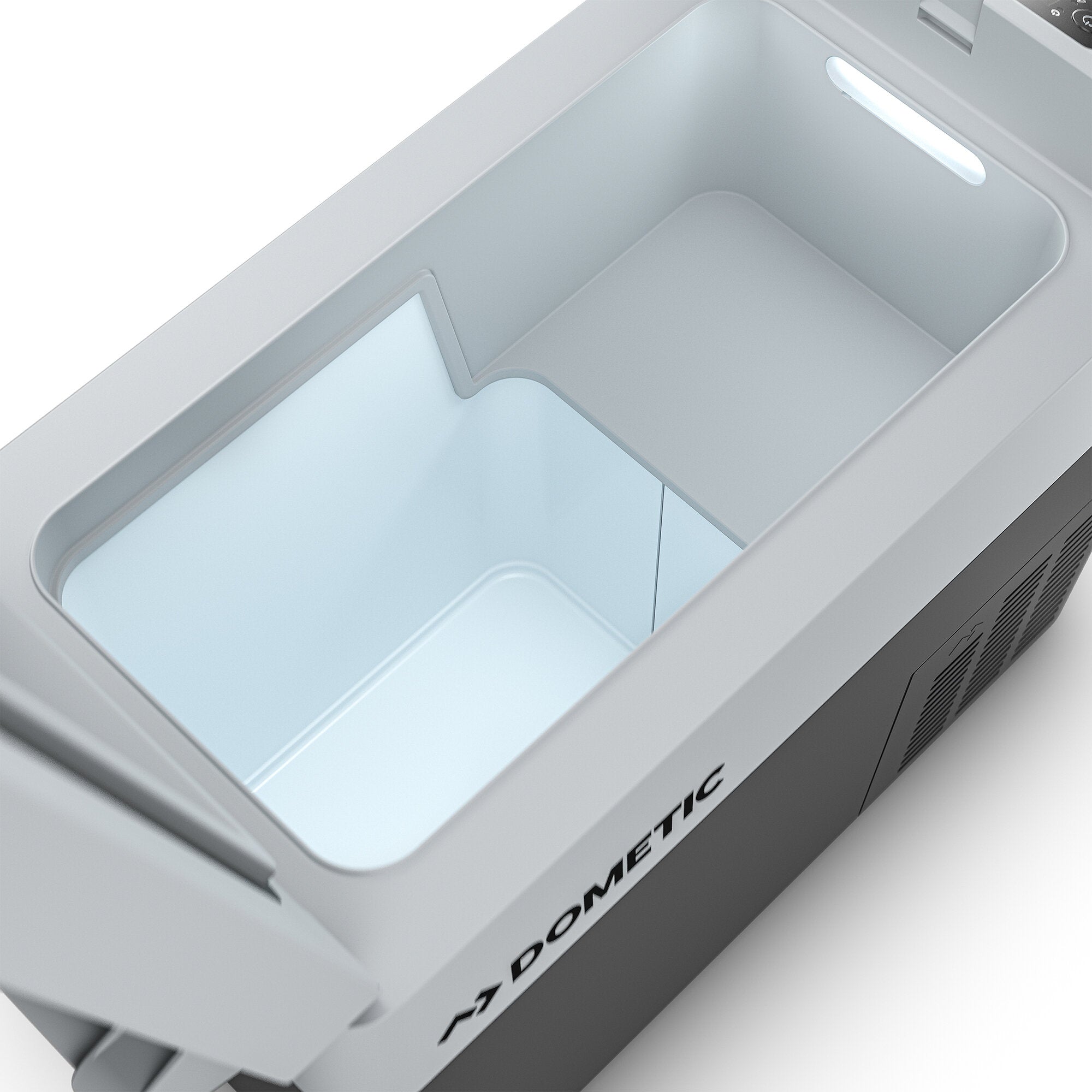 Innenraum einer kompakten DOMETIC Kühlbox, hellgraues Gehäuse, helle Innenbeleuchtung, seitlich sichtbarer DOMETIC-Schriftzug