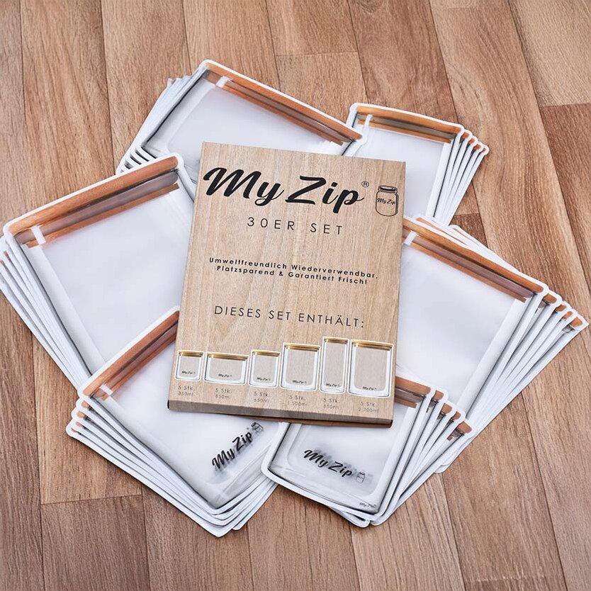 My Zip 30er Set Aufbewahrungsbeutel: Weiße Beutel mit braunen Reißverschlüssen, rund um ein Holzdisplay mit der Aufschrift My Zip 30er Set