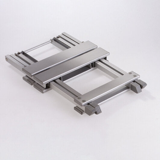 Silberner Metallrahmen eines Hocker Single mit parallel verlaufenden Schienen, querverbindenden Elementen und einer flachen Oberseite, auf weißem Hintergrund