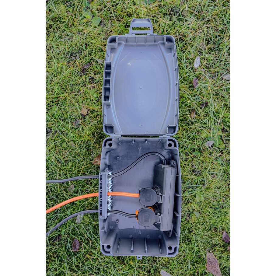 Aufgeklappte graue Wetterschutz-Box IP54 aus Kunststoff, Innenraum offen; zwei runde Steckdosenabdeckungen, orange und schwarze Kabel führen zu einem Anschlussmodul