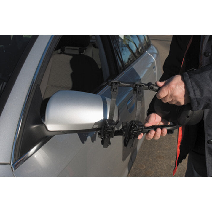 Person hält die Caravanspiegel Handy Mirror XL Standard-Halterung am äußeren Seitenspiegel eines silbernen Autos, verstellbares Gestell sichtbar