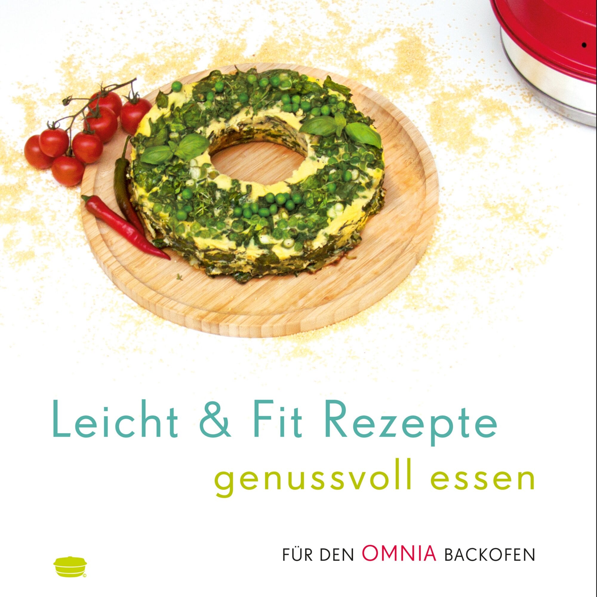 Ringförmige Kräuterquiche auf Holzbrett, bedeckt mit Basilikum, Erbsen und Spinat; Tomatenzweig und rote Chili daneben, roter Omnia-Backofen im Hintergrund