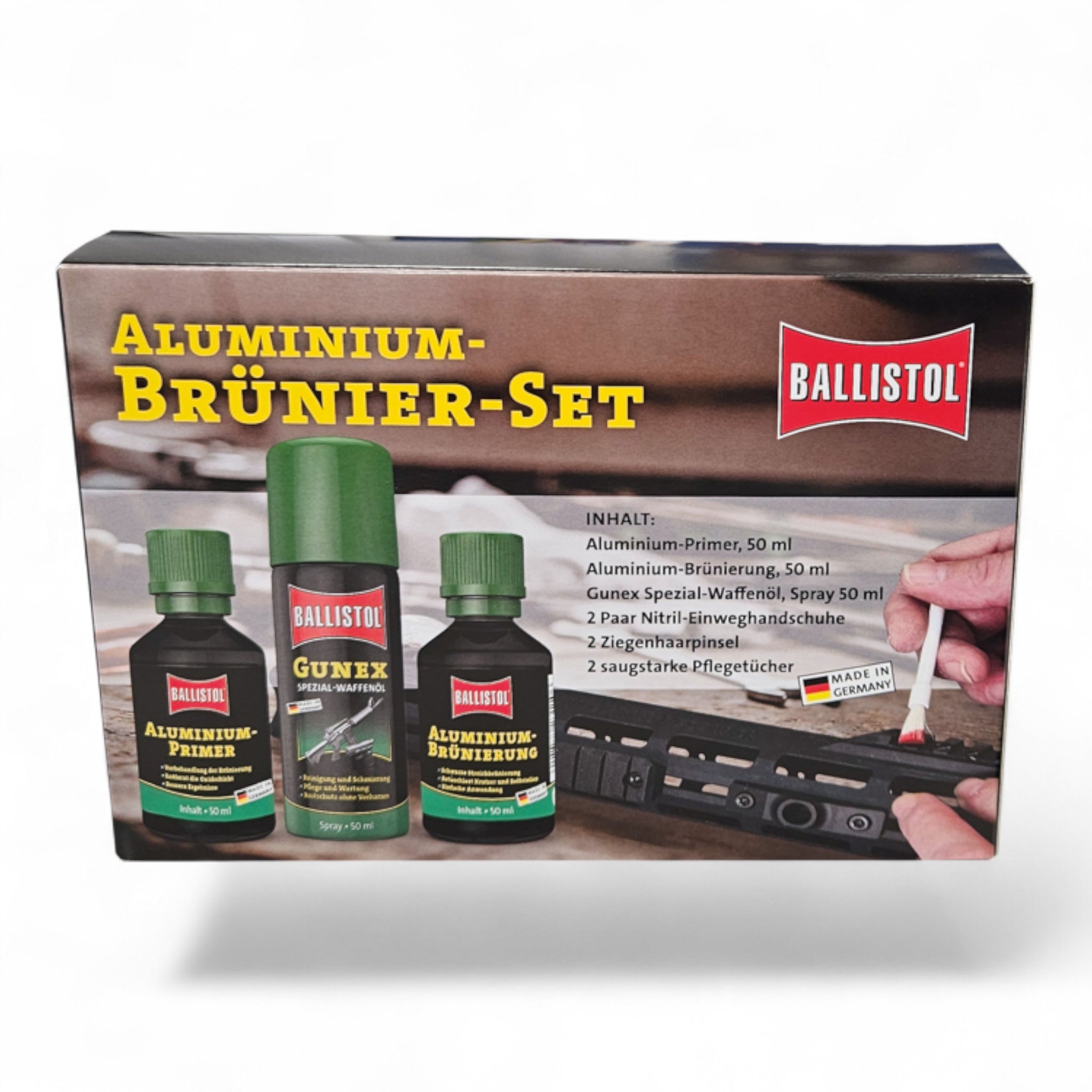 Ballistol Aluminium-Brünier-Set mit drei dunkelgrünen Flaschen und rotem Ballistol-Logo auf braunem Karton, daneben Hand,.